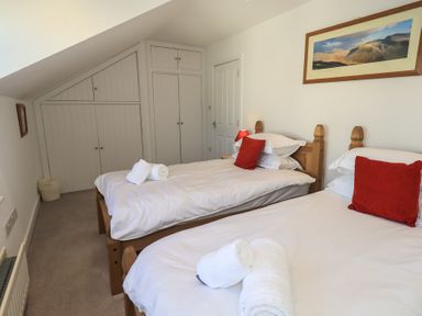 A bedroom with two beds and storage space at Swirl Howe in Keswick