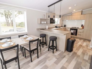 A kitchen with a dining area and bar stools at Dolphin in Haverfordwest