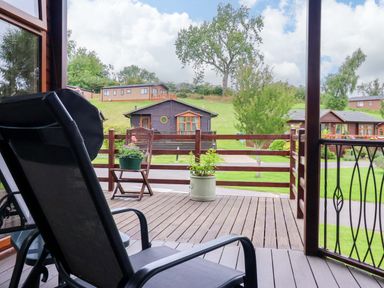A deck view with a chair and planter at Badgers Retreat - Two Dales, Richmond
