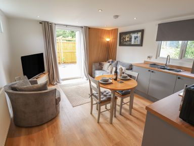 A living room with a sofa and a dining table at Pear Tree Lodge in Alford
