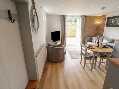 A living room with a table and chairs at Pear Tree Lodge in Alford