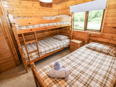 A bedroom with bunk beds and a single bed at Oak Lodge in Mynydd Cerrig near Porthyrhyd