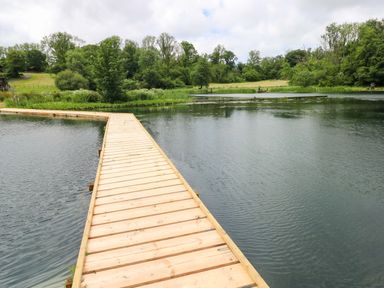 A wooden dock extending into a water body at Oak Lodge in Mynydd Cerrig near Porthyrhyd