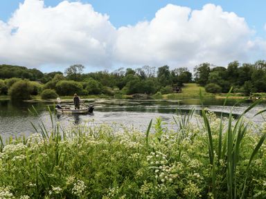 A boat on water with people fishing at Oak Lodge in Mynydd Cerrig near Porthyrhyd