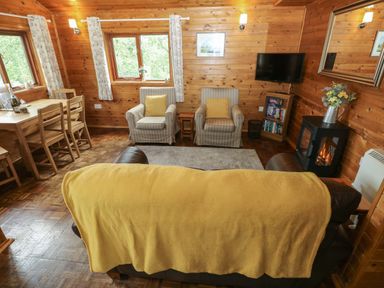 A living room with a sofa and armchairs at Ash Lodge near Mynydd Cerrig