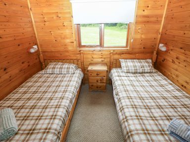 A bedroom with two beds and a window at Ash Lodge in Mynydd Cerrig near Porthyrhyd