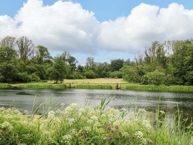 A lake with fishermen and vegetation at Ash Lodge, Mynydd Cerrig near Porthyrhyd