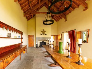 A dining room with a long table and candles at West Cottage in Llandovery