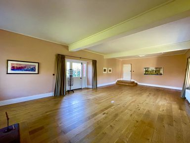 A living room with wooden floor and artwork on walls at West Cottage near Llandovery