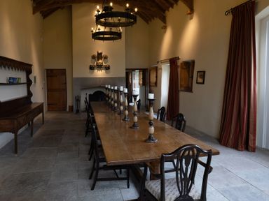 A dining room with a long table and chairs at West Cottage Myddfai near Llandovery