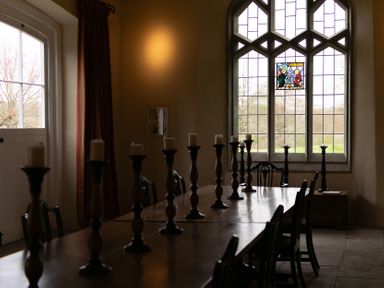 A dining room with a long table and candles at West Cottage in Myddfai near Llandovery