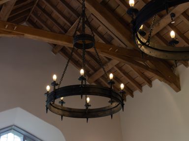 Two chandeliers hanging from a wooden ceiling at West Cottage in Myddfai near Llandovery