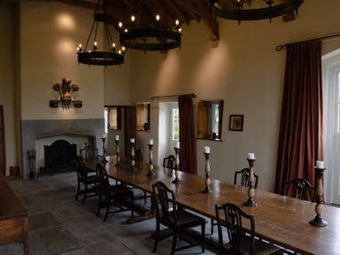 A dining room with a long table and chairs at West Cottage Myddfai near Llandovery