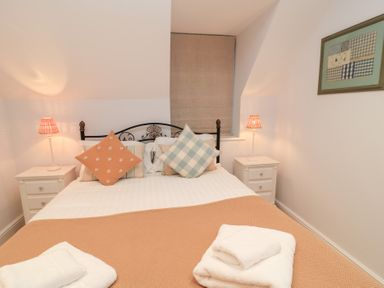 A bedroom with a bed and bedside tables at Peewit Coach House in Moreton-in-Marsh