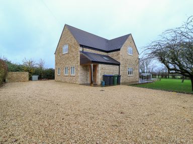 An exterior view of a house with gravel driveway at Peewit Coach House Moreton-in-Marsh