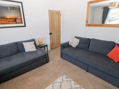 A living room with two sofas and a table at Hawthorns in Swansea