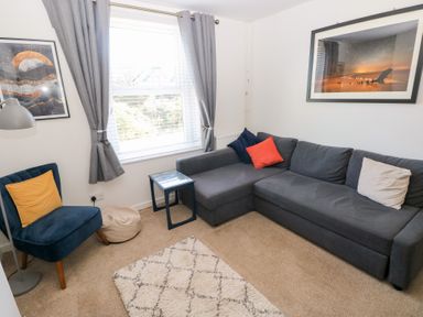 A living room with a sofa and armchair at Hawthorns in Swansea