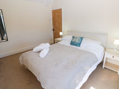 A bedroom with a bed and nightstand at Hawthorns in Swansea