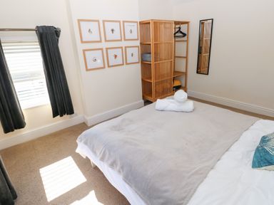 A bedroom with a bed and wardrobe at Hawthorns in Swansea