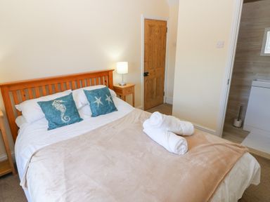 A bedroom with a bed and towels at Hawthorns in Swansea