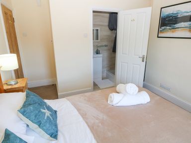 A bedroom with a bed and an attached bathroom at Hawthorns Swansea