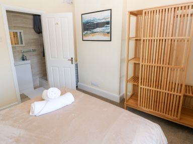 A bedroom with a bed and towels at Hawthorns in Swansea