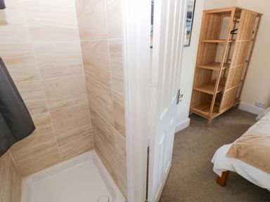 A shower and storage shelf in a bathroom at Hawthorns in Swansea