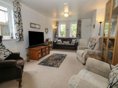 A living room with sofas and a television at June Cottage in Wool