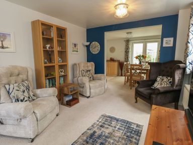 A living room with armchairs and a dining area at June Cottage in Wool