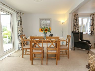 A dining room with a table and chairs at June Cottage in Wool