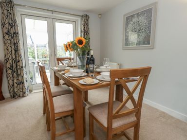 A dining room with a table set for a meal at June Cottage in Wool