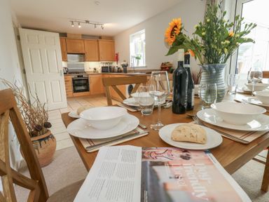 A kitchen with a dining table set at June Cottage in Wool