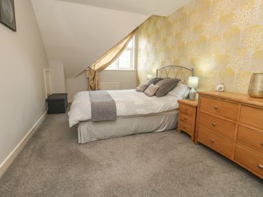 A bedroom with a bed and chest of drawers at June Cottage in Wool