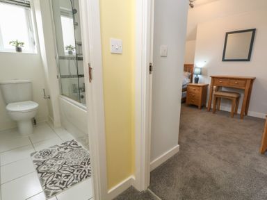 A bathroom with a toilet and bathtub at June Cottage in Wool