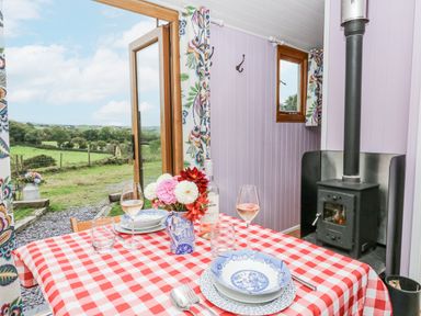 A dining area with a table set for a meal at Brondel Luxury Shepherd's Hut