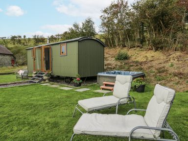 A garden with a shepherd's hut and hot tub at Brondel Luxury Shepherd's Hut in 