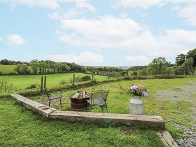 An outdoor area with chairs and a fire pit at Brondel Luxury Shepherd's Hut