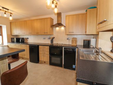 A kitchen with cabinets and appliances at Clawddcam in Mathry