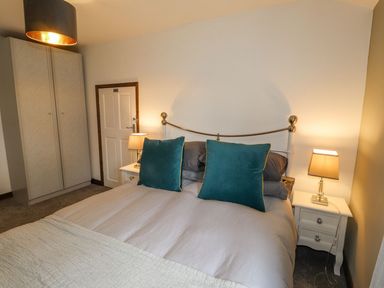 A bedroom with a bed and wardrobe at Clawddcam in Mathry