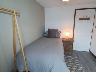 A bedroom with a bed and bedside table at Clawddcam in Mathry