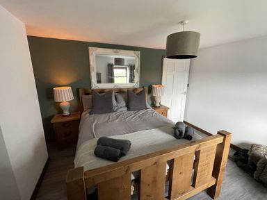 A bedroom with a bed and lamps at Clawddcam in Mathry