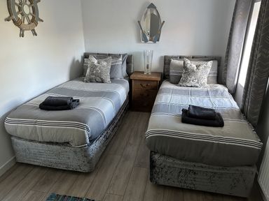 A bedroom with two beds and a nightstand at Clawddcam in Mathry