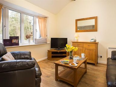 A living room with a sofa and coffee table at 2 Riverside Cottages Ambleside