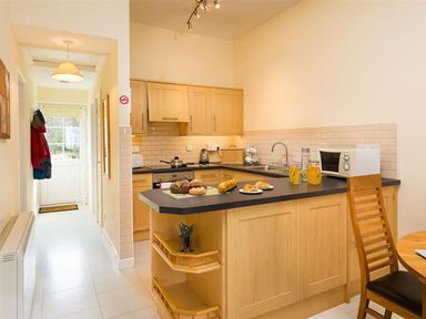 A kitchen with a countertop and dining table at 2 Riverside Cottages Ambleside
