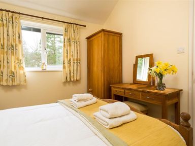 A bedroom with a bed and wardrobe at 2 Riverside Cottages Ambleside