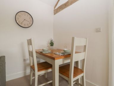 A dining room with a table and chairs at The Old Cart Shed in Gorsley