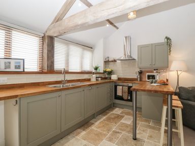 A kitchen with cabinets and countertop at The Old Cart Shed in Gorsley