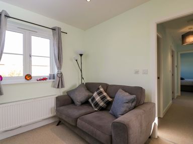 A living room with a sofa and window at Swallows Nest in Bourton-On-The-Water