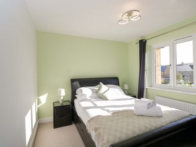 A bedroom with a bed and bedside lamps at Swallows Nest in Bourton-On-The-Water