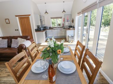 A dining room with a table set for a meal at Cadno in Llanybydder